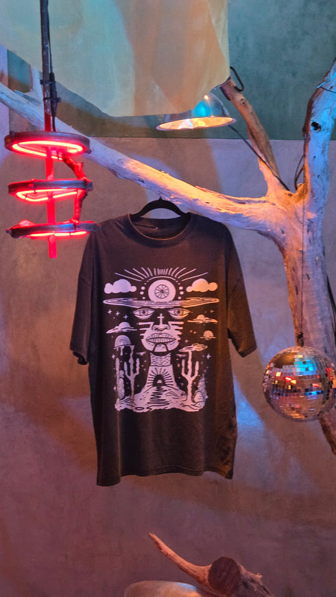 Black t-shirt with white graphic design on a surface with decorative elements