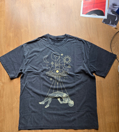 Black t-shirt with graphic design on a wooden surface