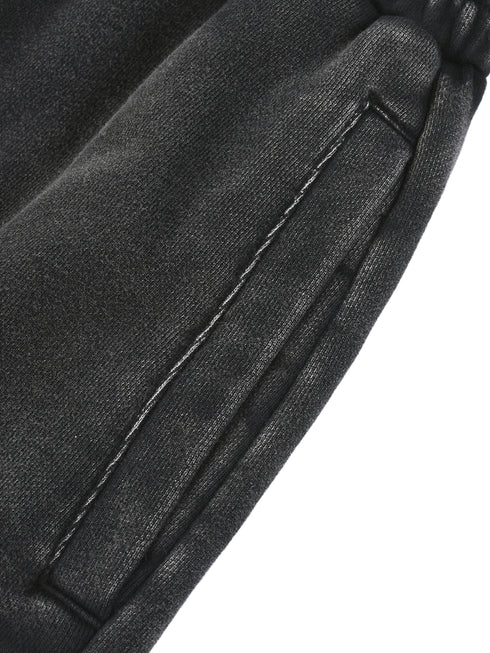 Close-up of a black leather jacket with stitching detail on a white background