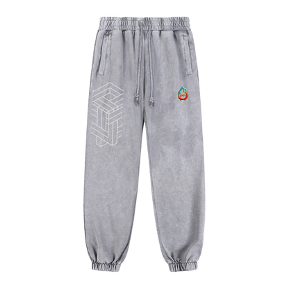 Gray sweatpants with geometric design and colorful logo on a white background