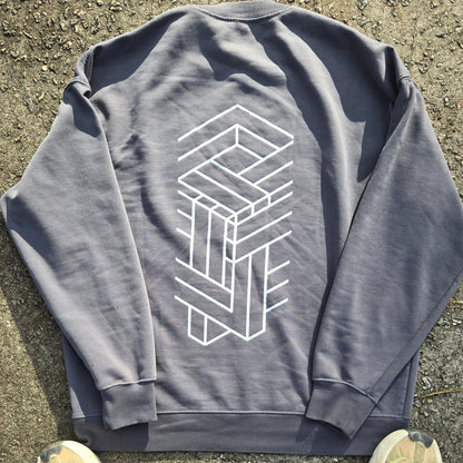 Gray sweatshirt with geometric design on a concrete surface, with shoes and pants partially visible.