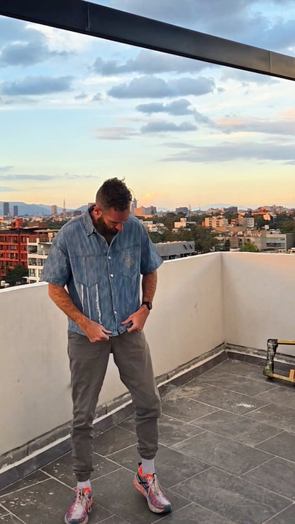 Man standing on a rooftop with a cityscape in the background